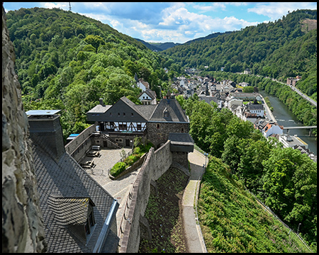 Vorburg einer Burg auf einem Bergsporn hoch über einem Flusstal mit einer Stadt