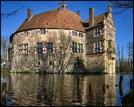 Burg Vischering mit markanter Auslucht und Spiegelung in der Gräfte