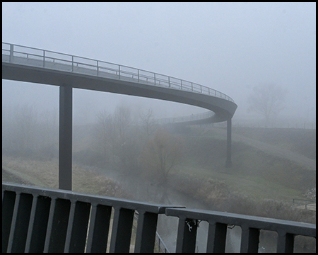 eine Brücke über einen Fluss im Nebel