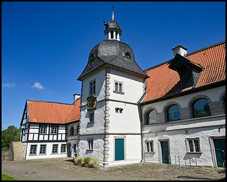 Ein Schloss mit einem markanten Turm und Fachwerkgebäude