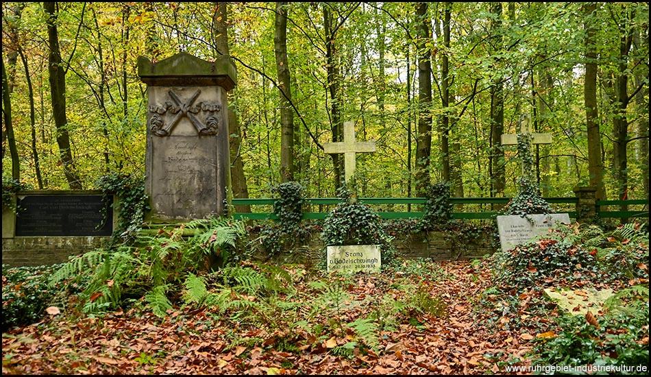 Grabsteine und Steinkreuze nebeneinander auf einem Waldfriedhof