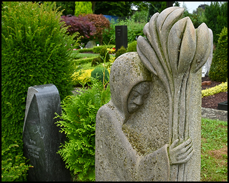 Grabsteine mit Figuren, die Pflanzen in der Hand halten