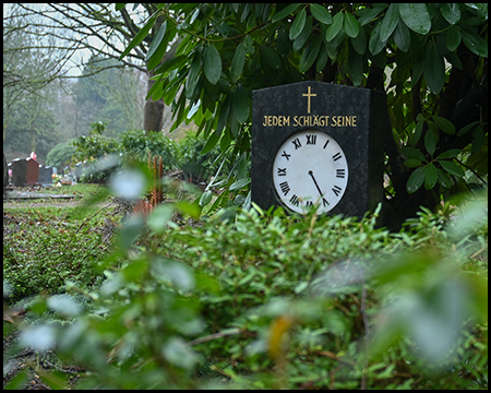 Ein Grabstein mit einer aufgemalten Uhr