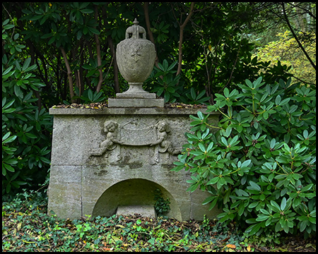 Ein markantes, altes Grab mit einer Art Vase aus Stein auf einem Steinblock