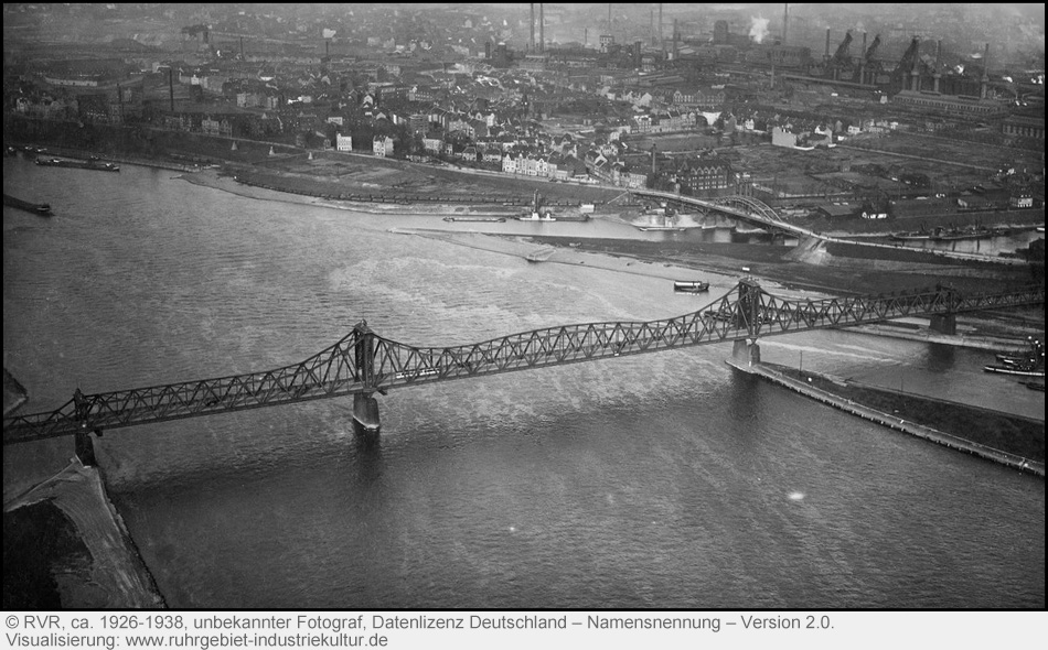 Alte Luftbildaufnahme einer Brücke über einen breiten Fluss