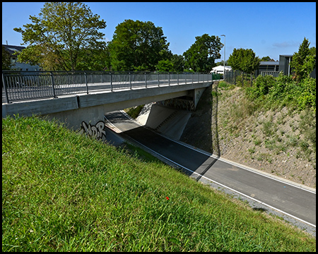 Eine Straßenbrücke über einen Radweg