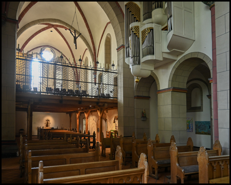 Im Innern einer Kirche mit Blick zur Rückseite mit Orgel an der Wand und einer Empore