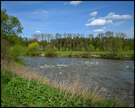 Ein Fluss, der zwischen Wiesen verläuft