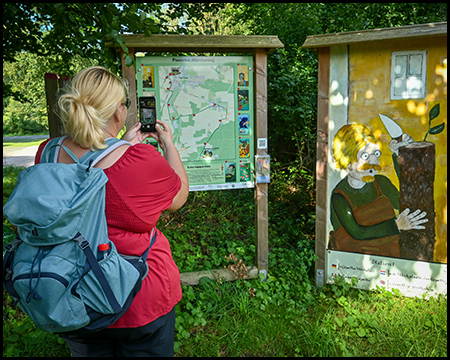 'Eine Frau fotografiert eine Wandertafel