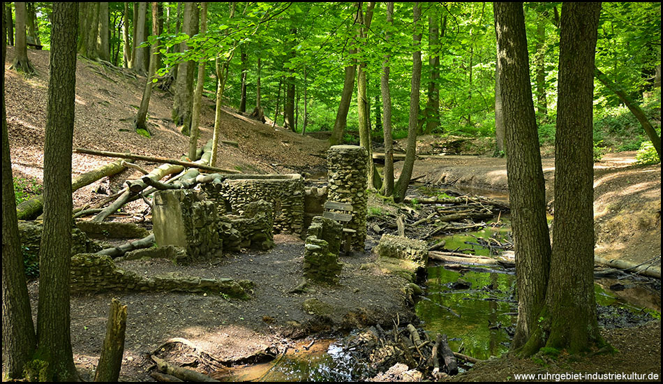 Kleines Modell einer Burg in einem wilden Bachtal im Wald