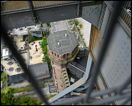 Blick durch ein Gitter auf Bauteile eines Turms