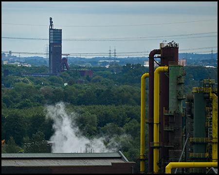 Förderturm der Zeche Nordstern im Hintergrund von Rohren einer Industrieanlage