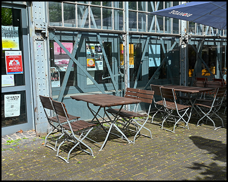 Tisch und Stuhl vor einem alten Industriegebäude