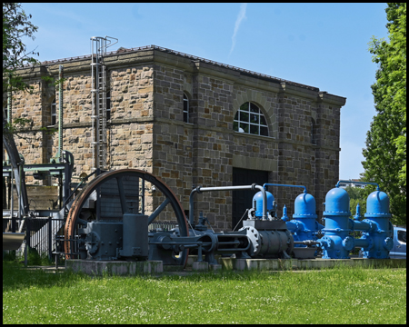 Teil eines Kraftwerks mit ausgestellten Demonstrationsobjekten mit einer blau lackierten Maschine
