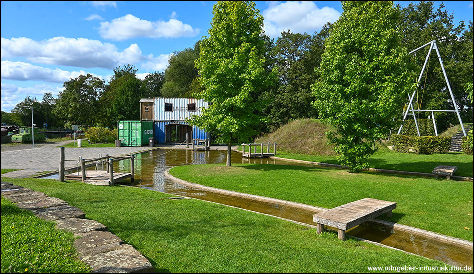 Spielplatz mit Wasserbereich und Schaukeln