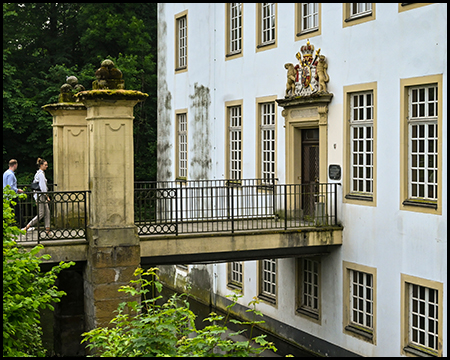 Brücke über einen Wassergraben zu einem Schlossgebäude