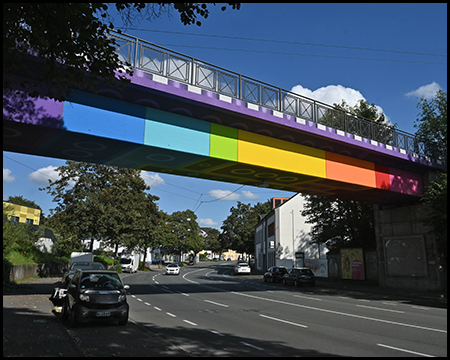 Eine Brücke über eine Straße, die durch ihren Anstrich aussieht, als bestünde sie aus farbigen Klemmbausteinen