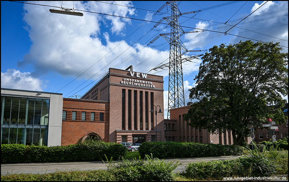 Gebäude des Umspannwerks Recklinghausen als großer Ziegelsteinbau. Im Hintergrund ein Hochspannungsmast.