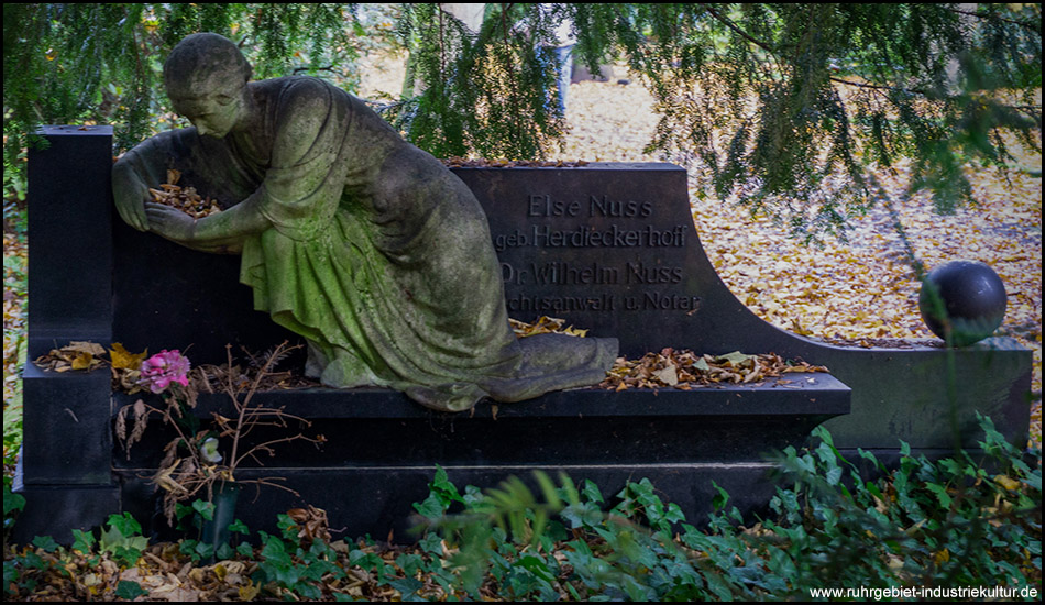 Grabstelle mit einer Figur auf dem Stein