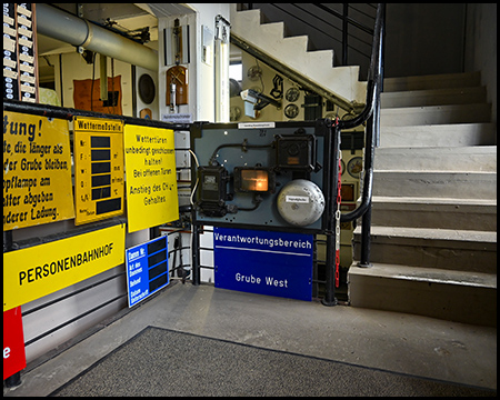 Treppe ins Obergeschoss, begleitet von vielen Schildern aus dem Bergbau